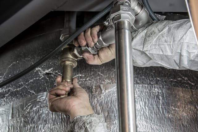 Plumber inspecting pipes